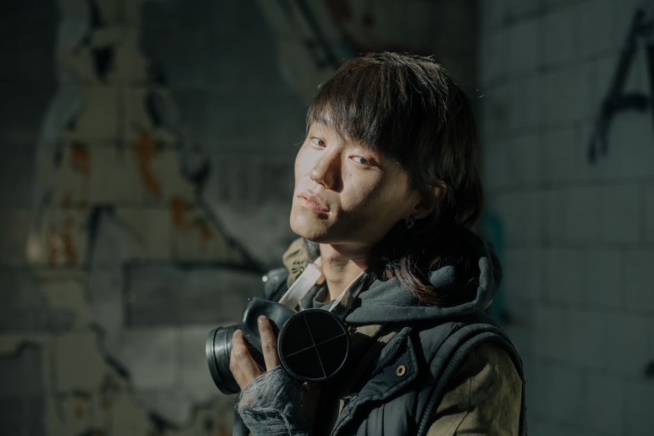 Portrait of a young man with gas mask in a decayed, urban setting.